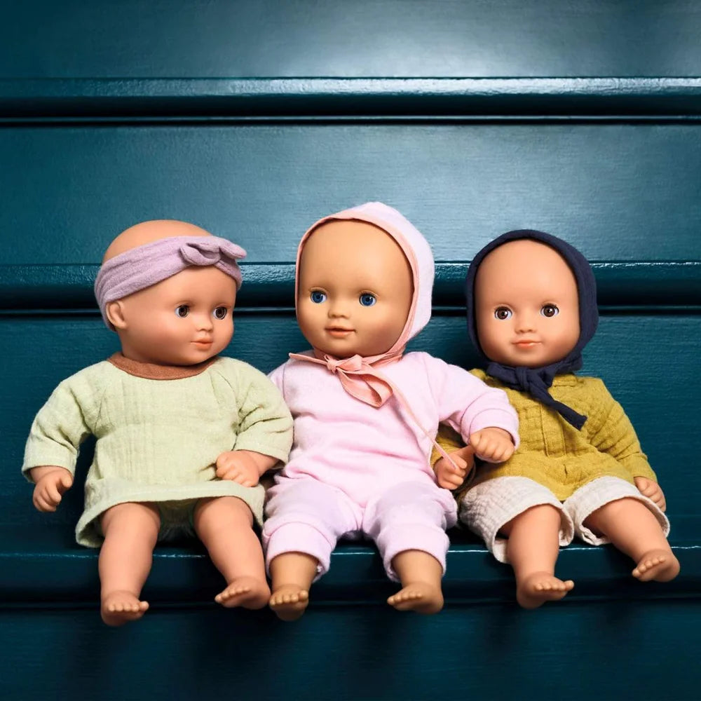 POMEA Puppe Lilas Rose - drei Babypuppen mit Kleidung sitzen zusammen ; POMEA Puppe Lilas Rose mit weiteren Babypuppen auf Treppe ; # POMEA Puppe Lilas Rose - Kind spielt mit Babypuppe auf SofaHier sind mehrere Alt-Text-Optionen in der geforderten Länge:1. **Kleines Mädchen spielt mit POMEA Babypuppe Lilas Rose**2. **Kind h