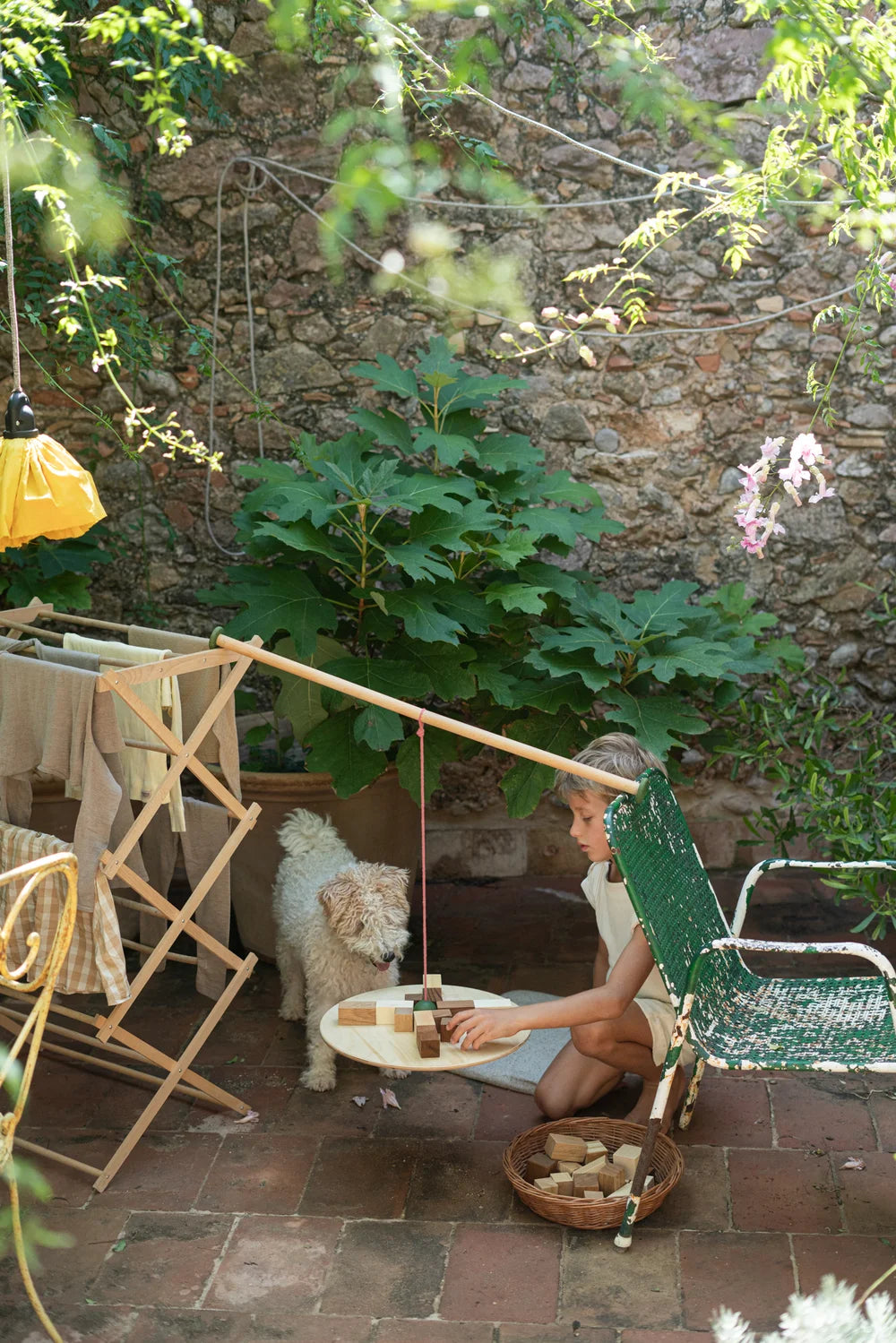 # Grapat Pendulum: Kind spielt mit Holzspielzeug im GartenKind spielt mit Grapat Pendulum Holzspielzeug im idyllischen Gartenhof.
