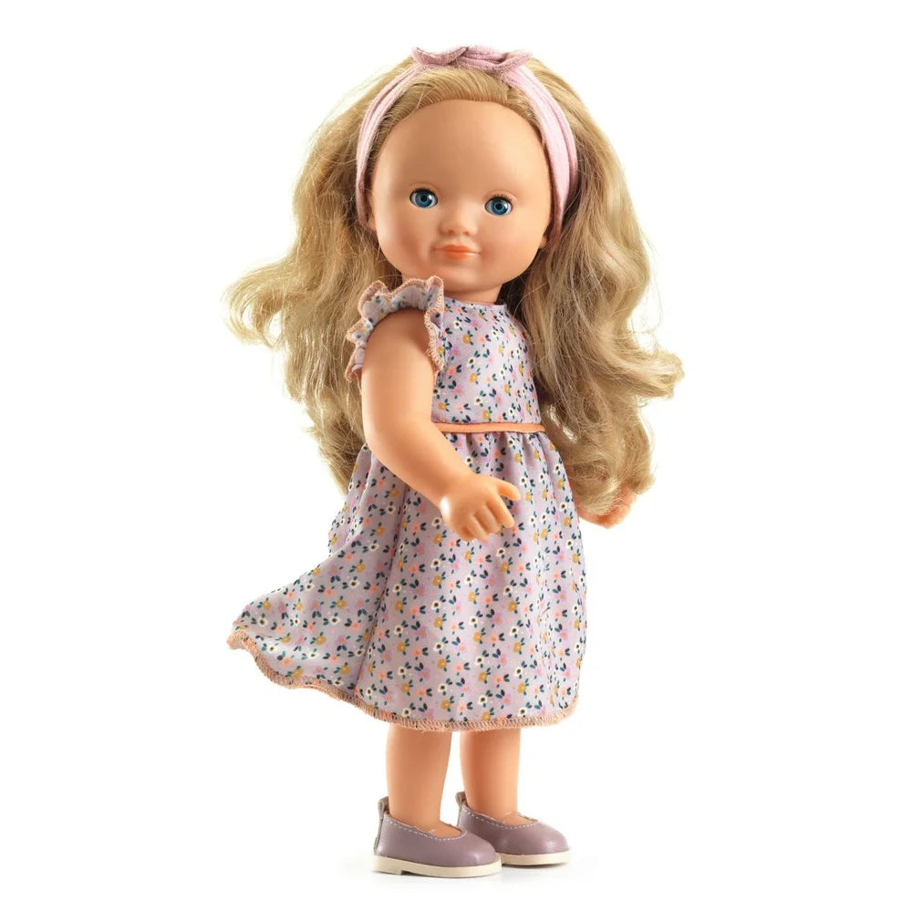POMEA Puppe Lovely Marie im Originalkarton mit Blumenkleid ; Kleines Mädchen küsst POMEA Puppe Lovely Marie mit blondem Haar ; Pomea Puppe Lovely Marie mit blondem Haar und Blumenkleid von Djeco ; POMEA Puppe Lovely Marie mit blondem Haar, rosa Haarband und Blumenkleid ; POMEA Puppe Lovely Marie mit goldblondem Haar von hinten ; POMEA Puppe Lovely Marie mit Holzkleiderstander und Puppenkleidung ; Kind spielt mit POMEA Puppe Lovely Marie und Stethoskop