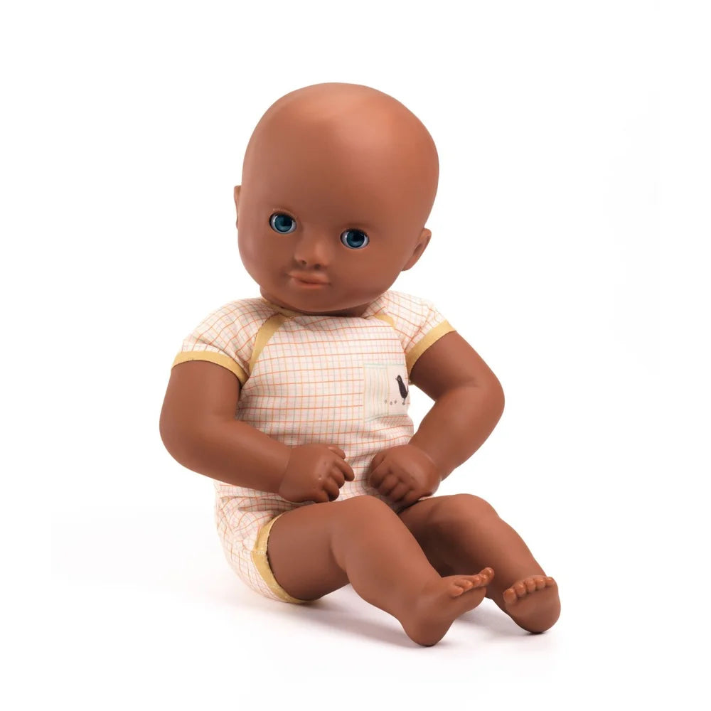 POMEA Puppe Issoria mit Bärenmütze und Stoffkleidung sitzt ; Pomea Puppe Issoria 32cm mit Bärenmütze und Schlafaugen ; POMEA Puppe Issoria mit Babykleidung sitzend auf weißem Hintergrund