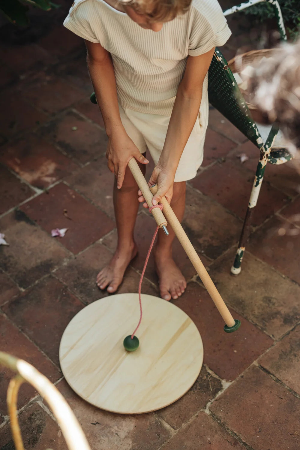Grapat Pendulum: Holzscheibe mit Schnur und grüner Kugel, Kind spielt