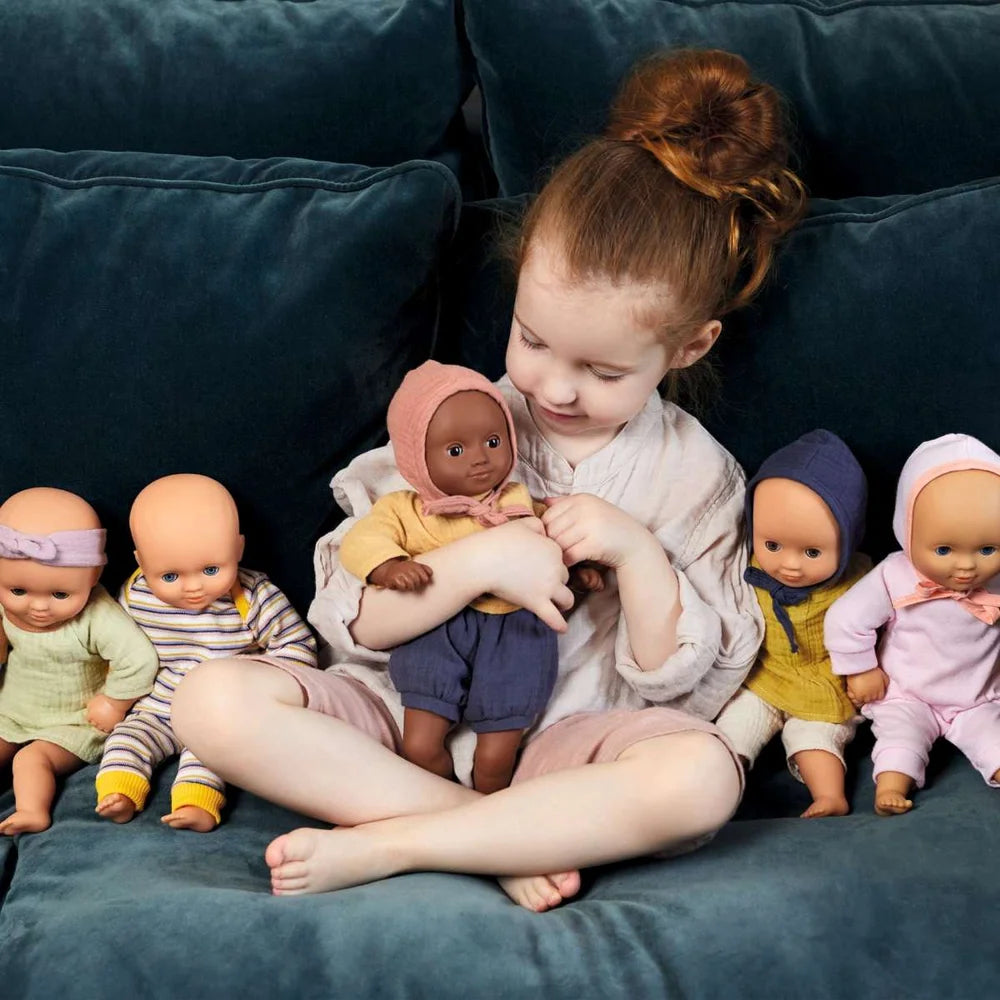 POMEA Puppe Lilas Rose - drei Babypuppen mit Kleidung sitzen zusammen ; POMEA Puppe Lilas Rose mit weiteren Babypuppen auf Treppe ; # POMEA Puppe Lilas Rose - Kind spielt mit Babypuppe auf SofaHier sind mehrere Alt-Text-Optionen in der geforderten Länge:1. **Kleines Mädchen spielt mit POMEA Babypuppe Lilas Rose**2. **Kind h