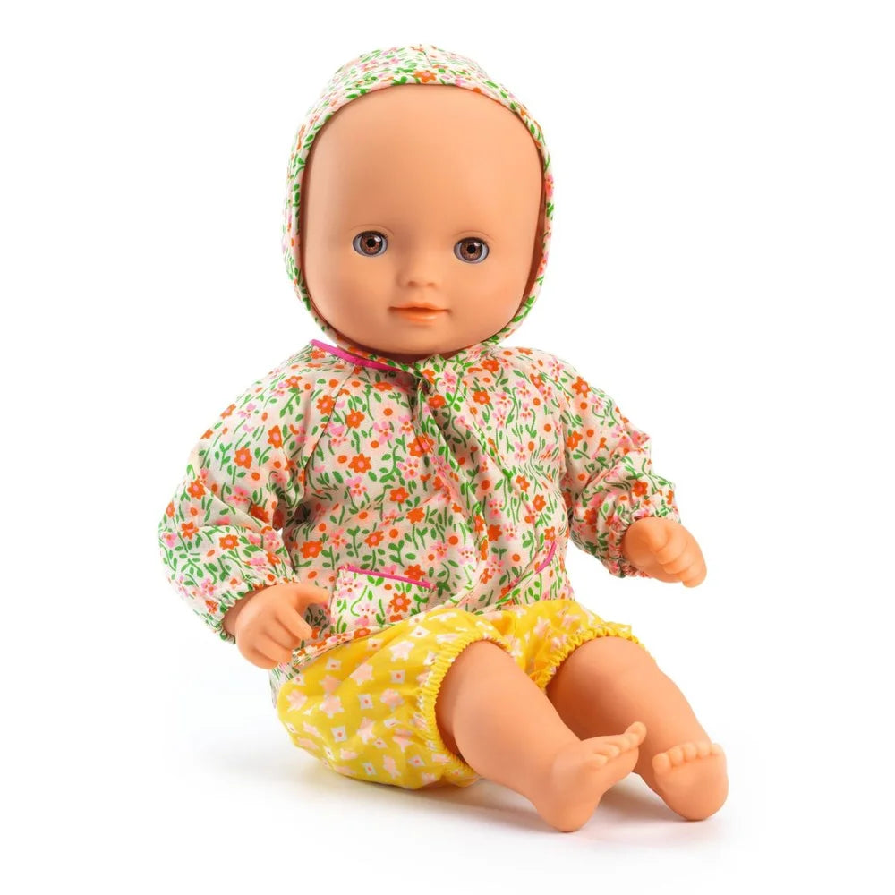 Baby-Puppe Flora in Blumenkleid und gelbem Outfit in Verpackung ; Pomea Baby Flora Puppe 32cm mit Blumenkleid und Haube ; POMEA Puppe Flora im farbenfrohen Blütenkleid sitzend ; POMEA Puppe Flora im rosa Pünktchen-Outfit sitzend