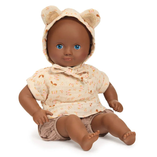 POMEA Puppe Issoria mit Bärenmütze und Stoffkleidung sitzt ; Pomea Puppe Issoria 32cm mit Bärenmütze und Schlafaugen ; POMEA Puppe Issoria mit Babykleidung sitzend auf weißem Hintergrund