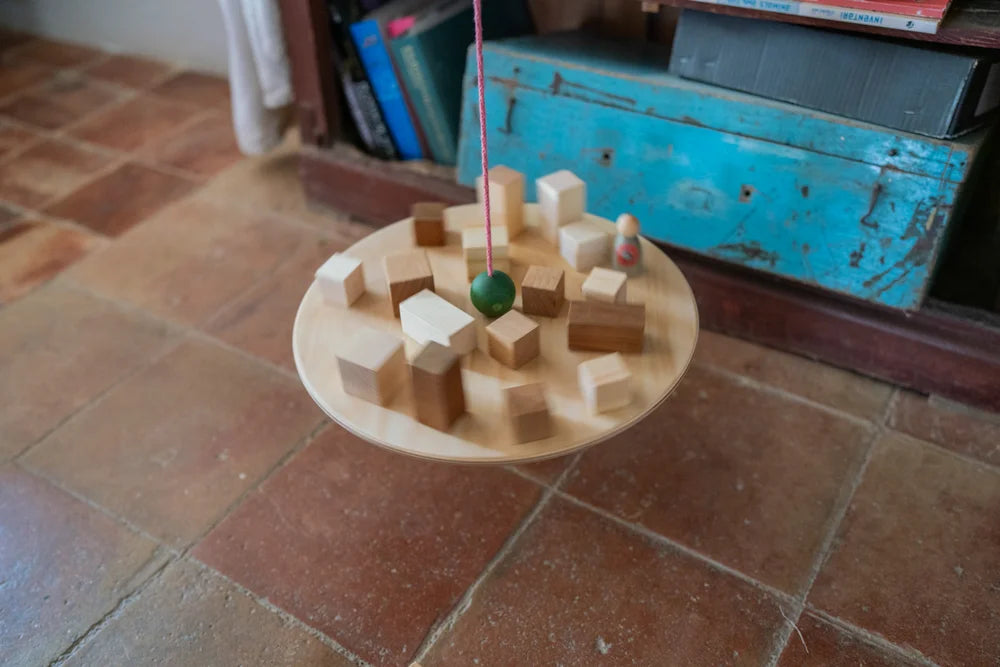 Grapat Pendel mit grüner Kugel über Holzblöcken auf Holztablett