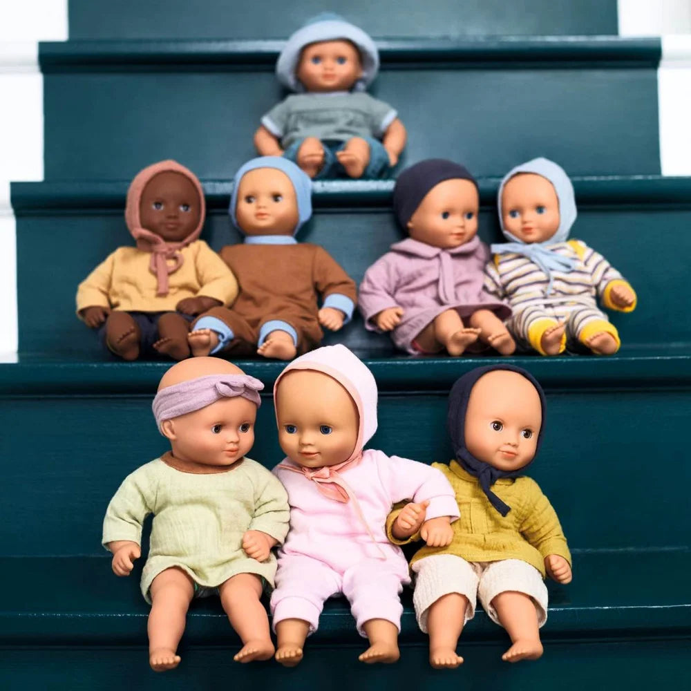 POMEA Puppe Lilas Rose - drei Babypuppen mit Kleidung sitzen zusammen ; POMEA Puppe Lilas Rose mit weiteren Babypuppen auf Treppe ; # POMEA Puppe Lilas Rose - Kind spielt mit Babypuppe auf SofaHier sind mehrere Alt-Text-Optionen in der geforderten Länge:1. **Kleines Mädchen spielt mit POMEA Babypuppe Lilas Rose**2. **Kind h