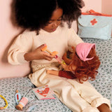 POMEA Puppe Lovely Sophie mit braunen Haaren und rosa-violettem Kleid ; POMEA Puppe Lovely Sophie mit rosa Oberteil und lila Rock, 32 cm ; POMEA Puppe Lovely Sophie mit roten Locken und lila Unterwäsche ; POMEA Puppe Lovely Sophie mit braunem Haar und rosa Haarband ; Kleines Mädchen spielt mit POMEA Puppe Lovely Sophie im Kinderwagen ; # Kind spielt mit POMEA Puppe Lovely Sophie und Zubehör ; Kind spielt mit POMEA Puppe Lovely Sophie im Puppenbett ; Kind spielt mit POMEA Puppe Lovely Sophie im Holzbett