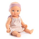 POMEA Badepuppe Mädchen Prune in rosa-weißem Kleid mit Mütze ; POMEA Badepuppe Mädchen Prune mit rosa Badeanzug und Stirnband ; POMEA Badepuppe Baby Prune 32cm mit rosa Outfit und Kopftuch ; POMEA Badepuppe Mädchen Prune liegt auf Wickelunterlage auf Tuch ; Kleines Mädchen mit POMEA Badepuppe in Rosa spielend auf Bett ; Mädchen mit POMEA Badepuppe in rosa Puppenkleidung spielend ; POMEA Badepuppe Mädchen Prune mit Zubehör beim Baden spielen