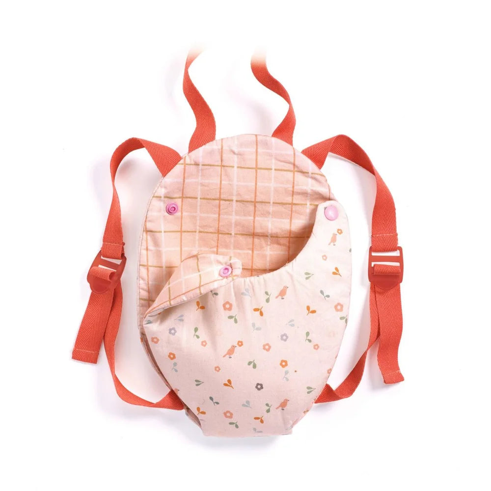 POMEA Puppentrage Lavender mit buntem Blumenmuster, rosa Details ; Pomea Puppentrage Lavender mit Puppe auf Produktverpackung ; POMEA Puppentrage Lavender mit roten Trägern und Blumenmuster ; POMEA Puppentrage Lavender mit kleiner Puppe, rot-weiß gestreift ; Kleines Mädchen trägt POMEA Puppentrage mit Puppe am Körper ; Kleines Mädchen trägt Puppe in POMEA Puppentrage Lavender