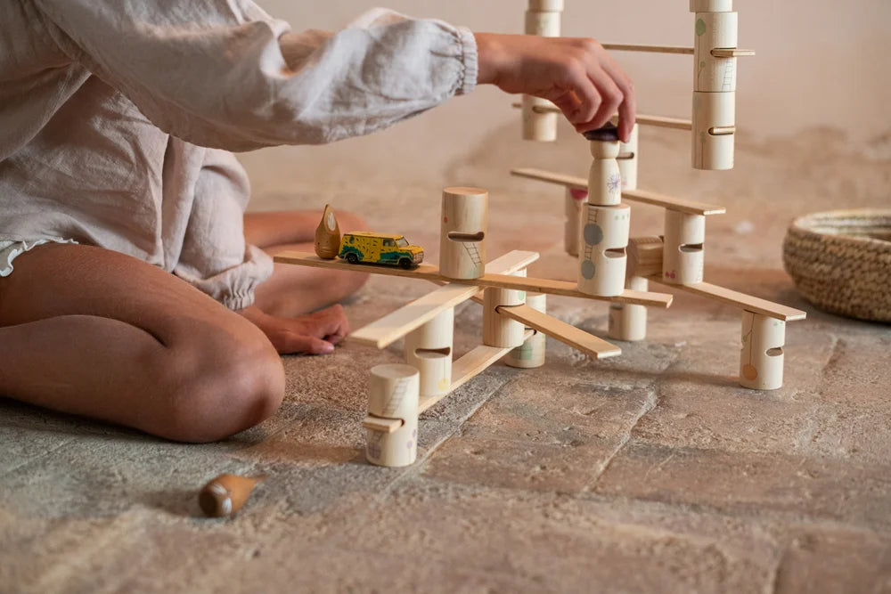 Kind spielt mit Grapat Woodland Holzbausteinen und Spielzeugauto