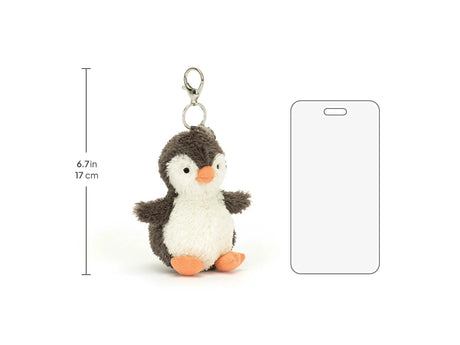 Jellycat Peanut Penguin Schlüsselanhänger neben Größenvergleich mit Smartphone
