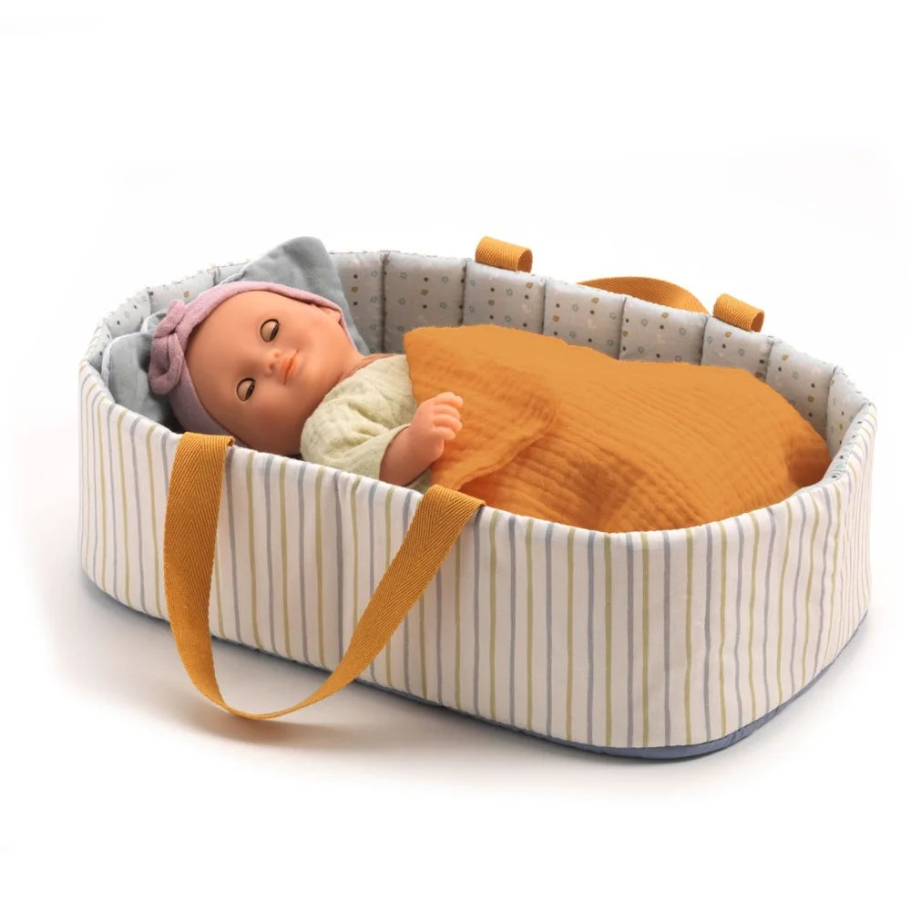 POMEA Puppentragetasche Blue Lines mit Puppe und Zubehör ; # POMEA Puppentragetasche mit orangenen Griffen und gestreiftem Design ; Kleines Kind mit POMEA Puppentragetasche Blue Lines und Puppe auf gelbem Sofa. ; POMEA Puppentragetasche Blue Lines mit Zubehör, Djeco Kollektion ; Puppentragetasche mit Puppe, gestreiftem Design und orangefarbenen Henkeln